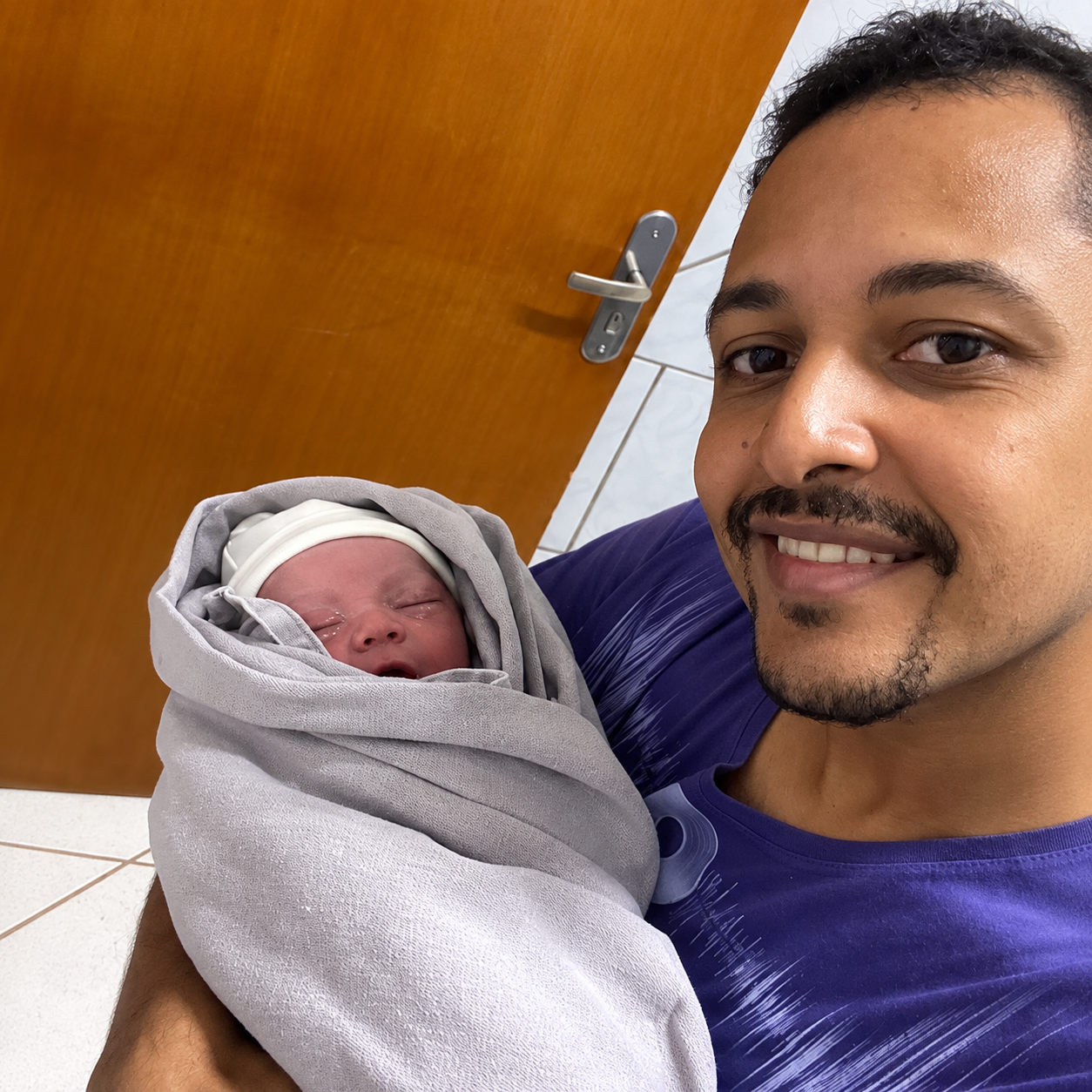 O pai, Alan Barbosa, com o filho recém-nascido no colo — Foto: Reprodução